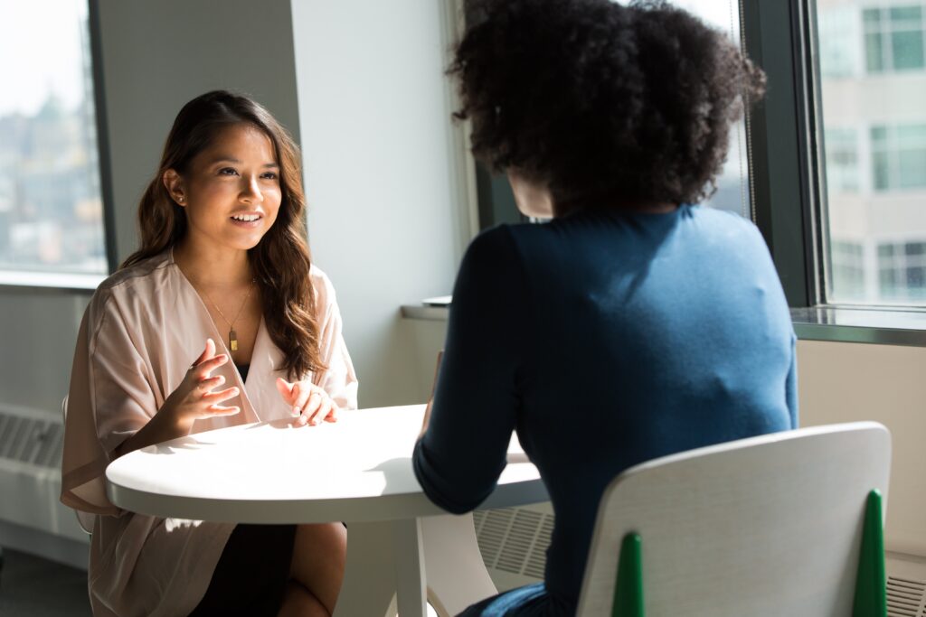 two women talking, on a table